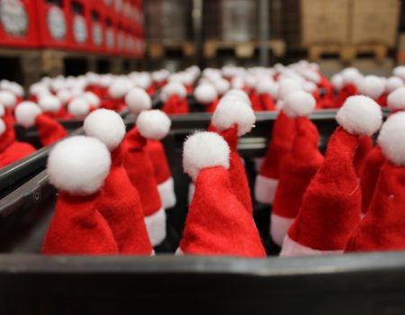 Weihnachtsmützen auf Bierflaschen bei der Produktion von Bier-Adventkalendern
